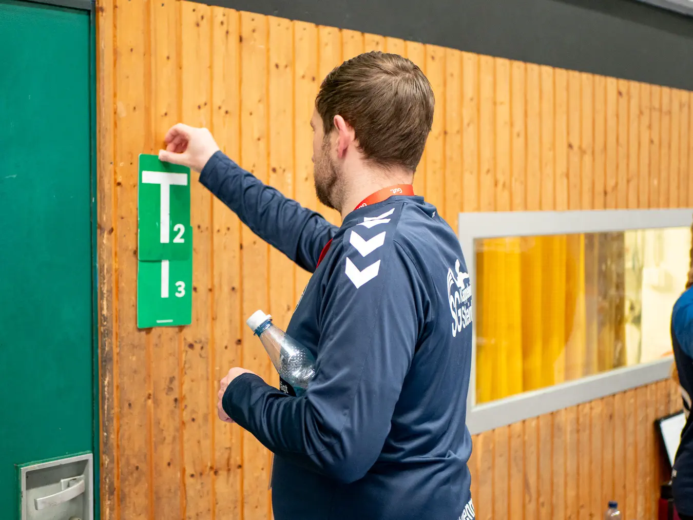 Ein Kappelwindecker Offizieller klebt Team-Timeout-Karten an die Hallenwand.
