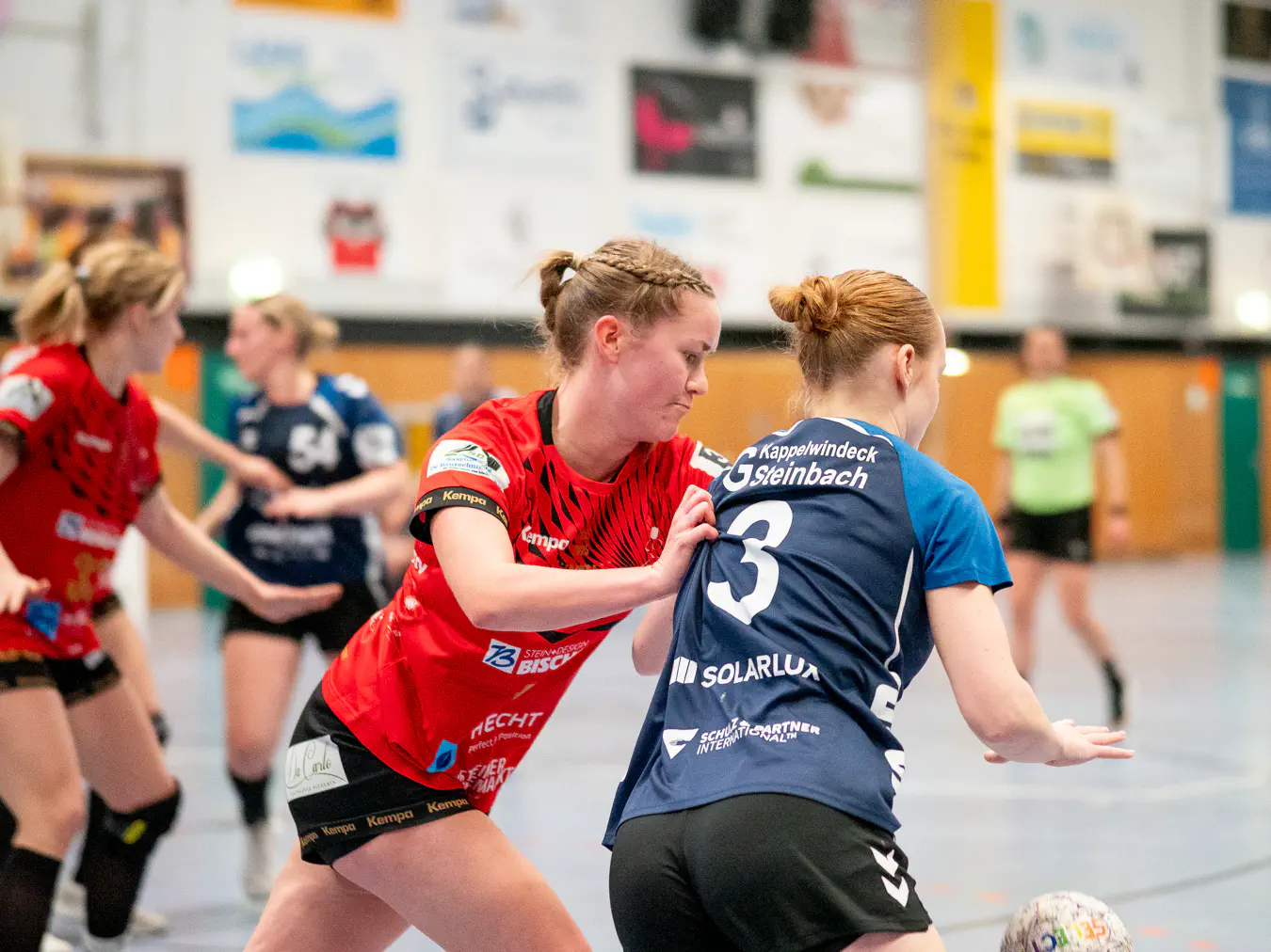 Eine Schozacher Verteidigerin schiebt eine Kappelwindecker Angreiferin an der Schulter und versucht, den gedribbelten Ball zu erreichen.