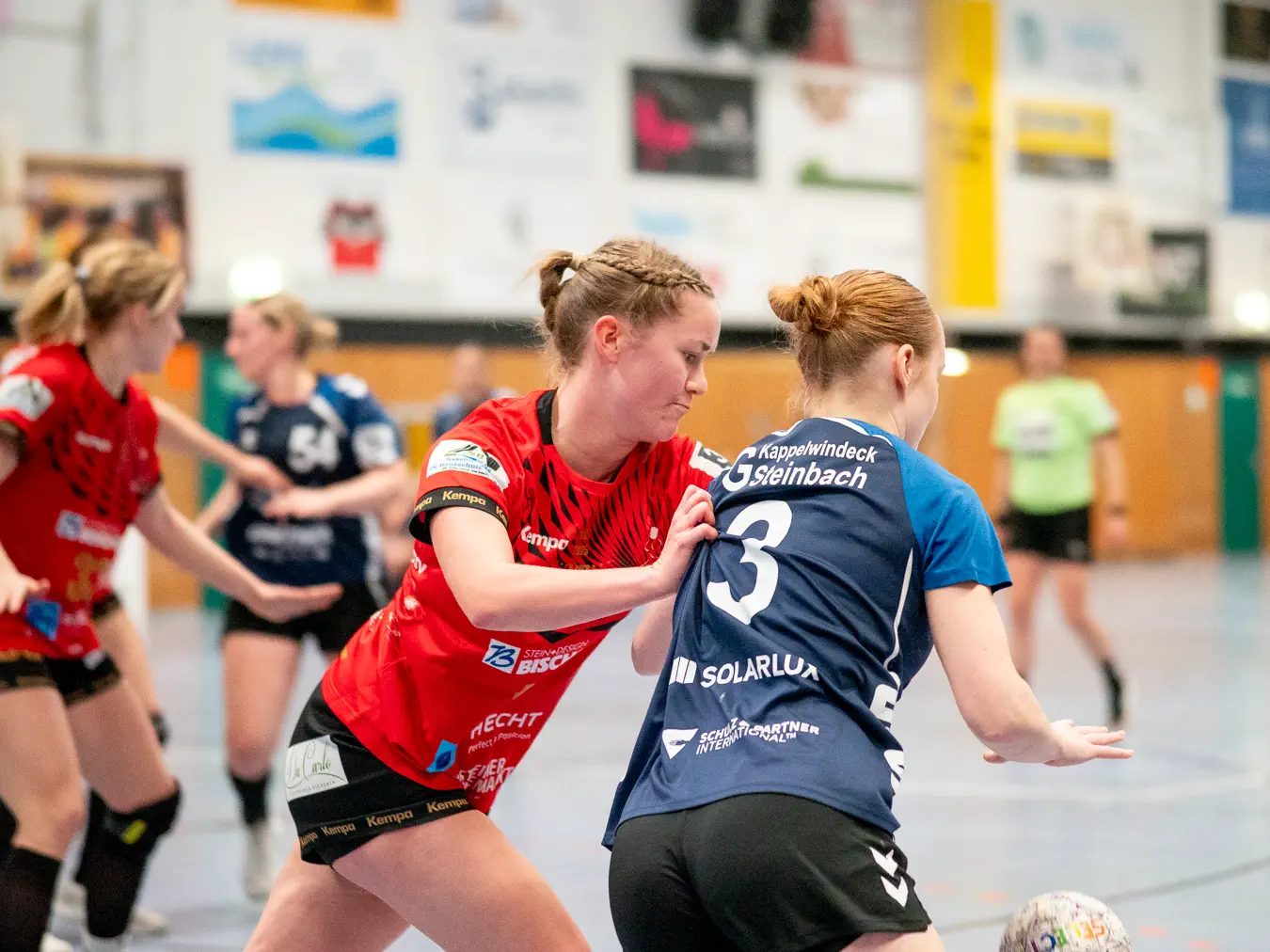 Eine Schozacher Verteidigerin schiebt eine Kappelwindecker Angreiferin an der Schulter und versucht, den gedribbelten Ball zu erreichen.