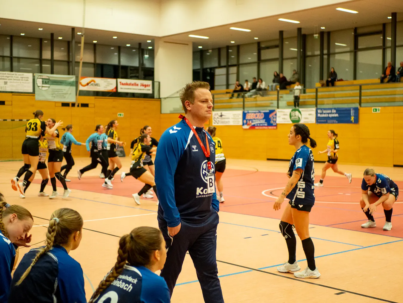 Im Hintergrund jubelnde Ismaninger Spielerinnenauf dem Feld, rechts enttäuschte Kappelwindeck/Steinbachereinnen, mittig der enttäuschte SGKS-Trainer.