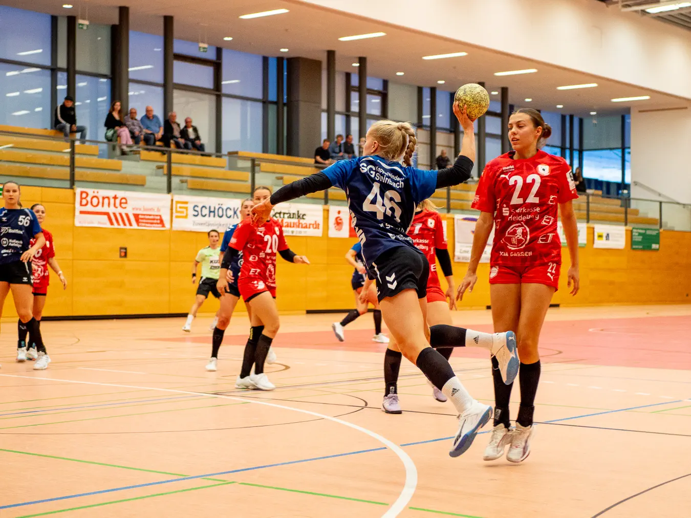 Eine Frau im Sprungwurf von der Außenposition in Richtung Tor.