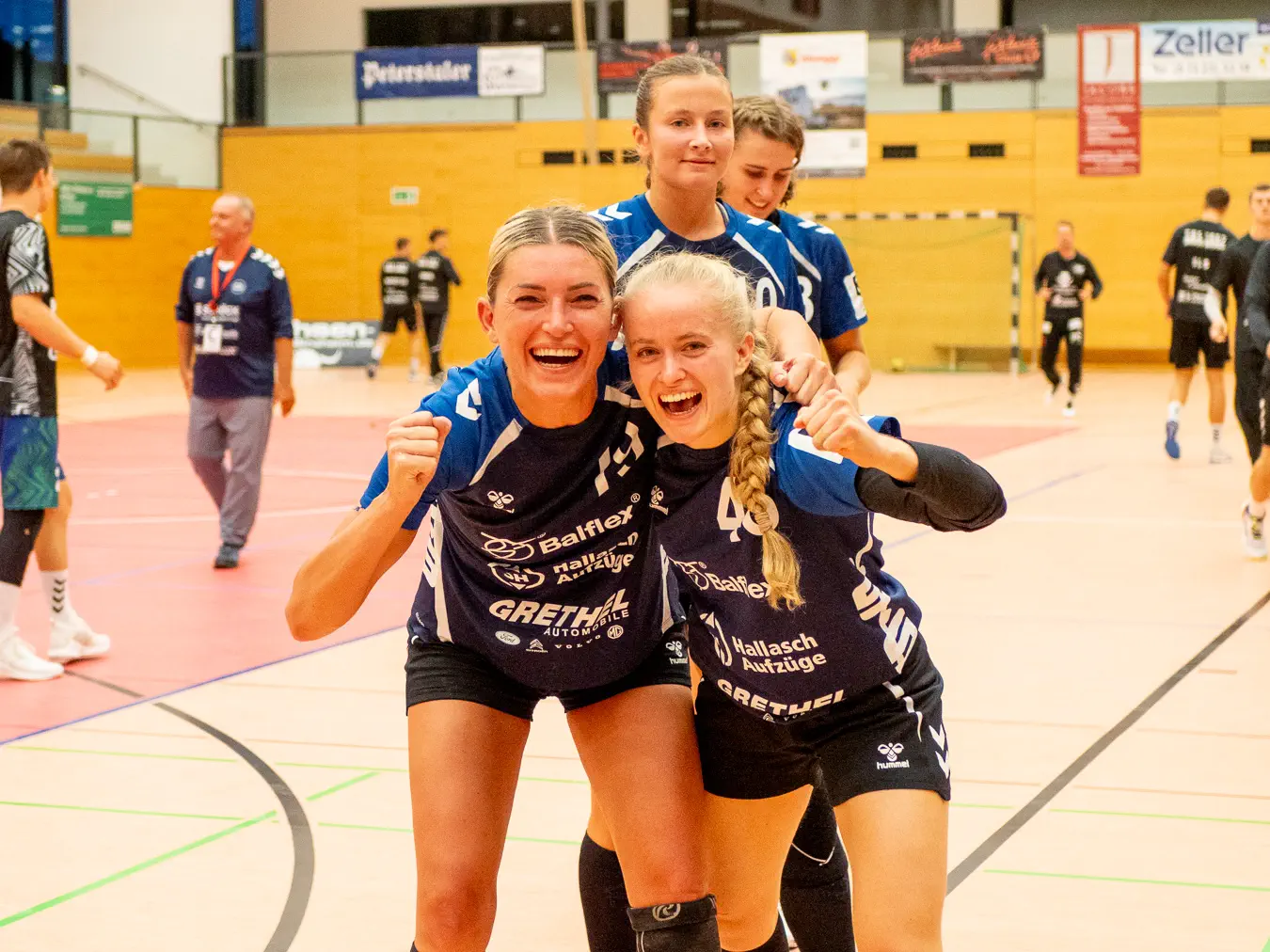 Zwei Frauen umarmen sich und schauen jubelnd in die Kamera.