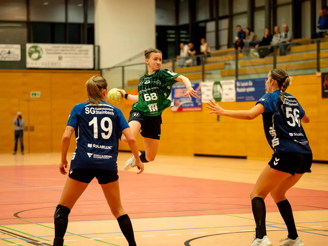 Eine Angreiferin im Sprungwurf, einige Meter vor zwei Verteidigerinnen.